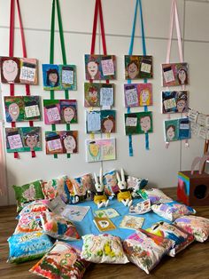 a table covered with pillows and pictures hanging on the wall