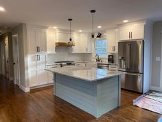 a large kitchen with an island and stainless steel appliances in the middle of the room