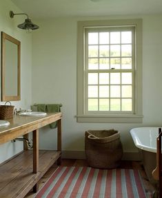 a bath room with a tub a sink and a mirror on the wall in front of a window