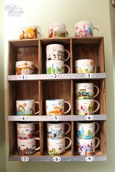 coffee mugs are lined up on a shelf with numbers and pictures in each cup