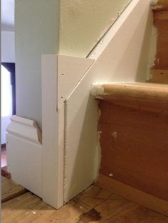 an unfinished stair case next to a white door