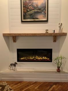 a fireplace with a painting on the wall above it and a fire place in front of it