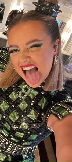 a woman with her tongue out and some hair clips on top of her head, making a silly face