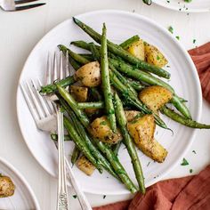 a white plate topped with green beans and potatoes