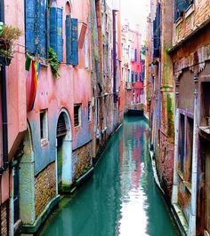 a narrow canal runs between two buildings in venice