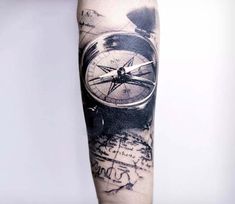 a man's arm with a compass tattoo on it