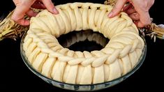 two hands are pulling out the ends of a bundt cake in a glass bowl