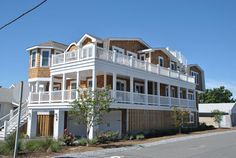 a two story house with balconies on the top floor and second story above it