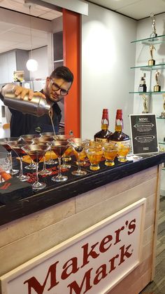 a man behind a counter filled with drinks