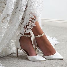 a woman wearing white high heels with lace