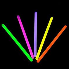 neon colored straws are lined up against a black background