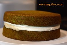 a green cake with white frosting on a plate