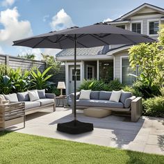 an outdoor living area with couches and umbrella