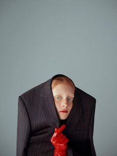 a man in a suit and red rubber gloves