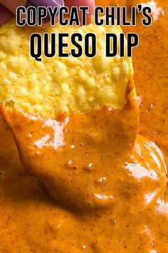 a hand holding a tortilla chip over a bowl of queso dip