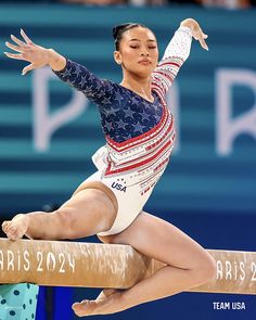 a woman is performing on the balance beam