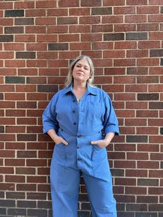 This boiler suit is made for movement and comfort, with darts at the back for a feminine touch. Contrast colors at undercollar and sleeve cuff. The style features a wide pant leg and a shorter inseam, so if you’re taller than 5’8”, you get to show off your sexy ankles (or kooky socks or Doc Martens or whatever). We recommend choosing according to your hip measurement or pant size. If you have a favorite jumpsuit please use it as a guide. Size XS fits US pant size 2-4 Chest 37”, Waist 28”, Hip 39 Solid Denim Jumpsuit With Pockets For Work, Blue Denim Jumpsuit With Relaxed Fit And Long Sleeves, Blue Long Sleeve Relaxed Fit Denim Jumpsuit, Blue Cotton Denim Jumpsuit With Long Sleeves, Blue Cotton Long Sleeve Denim Jumpsuit, Blue Long Sleeve Cotton Denim Jumpsuit, Full Length Overalls With Pockets For Work, Blue Long Sleeve Overalls For Spring, Fitted Long Sleeve Overalls With Pockets