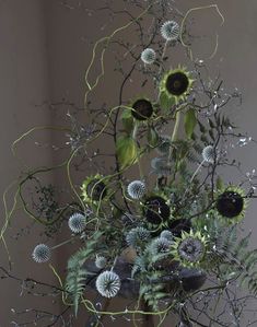 a vase filled with lots of different types of flowers and plants on top of a table