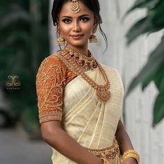 a woman in a white sari with gold jewelry