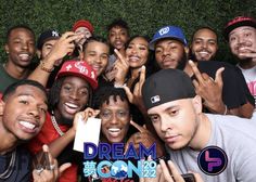 a group of young men and women posing for the camera with their hands in the air