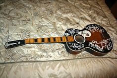 a black and white guitar laying on top of a bed