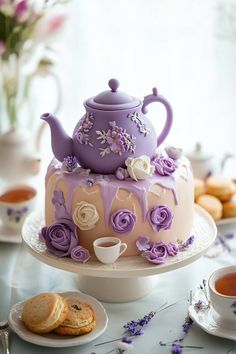 there is a cake with flowers on it and a teapot sitting on the top