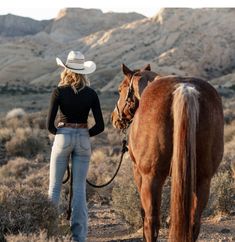 a woman walking her horse in the desert