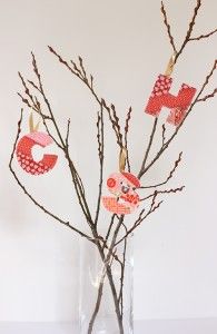 a vase filled with branches and paper hearts