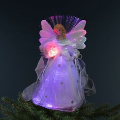 a lighted angel ornament sitting on top of a christmas tree with purple lights