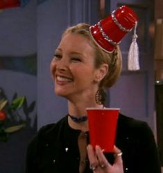 a woman with a red cup in her hand and a hat on top of her head