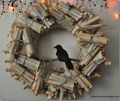 a wreath made out of books with a black bird sitting on it