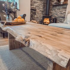 a wooden table with fruit on it in front of a fire place and couches