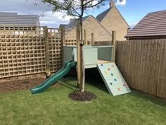 there is a play area in the back yard with a slide and climbing wall for children to climb on