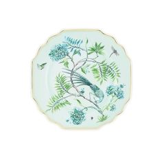 a blue and green plate with birds on it, surrounded by leaves and flowers in the center