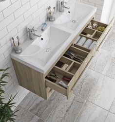 a bathroom with two sinks and an open drawer in the middle that holds utensils