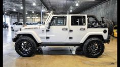 a white jeep is parked in a garage