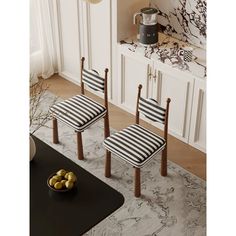 two black and white striped chairs in a living room with a bowl of fruit on the floor