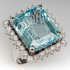 This marvelous ring is centered with one (1) emerald cut natural aquamarine set into a four-prong setting. The center stone is bordered with twenty-six (26), prong set, round brilliant cut diamonds. The ring measures 23.1mm at the top, rises 12.6mm above the finger, tapering to 3.4mm wide and 0.9mm thick at the base of the shank. This ring is currently a size 6.25. Aquamarine Cocktail Ring, Shape Fashion, Aquamarine Jewelry, Aquamarine Ring, Diamond Cocktail Rings, Aquamarine Rings, Christmas Gift Jewelry, Natural Aquamarine, Blue Gemstones