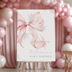 a welcome sign for a baby shower with pink and white balloons in the back ground