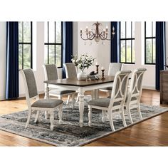 a dining room table with chairs and a rug