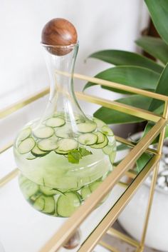 a glass bottle filled with cucumbers sitting on top of a table