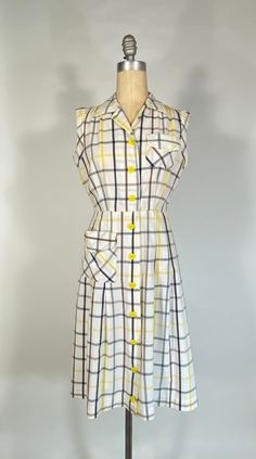 "Get ready for some action, in this vintage sports dress, from Activi-Tee! This is the perfect summer dress for running around in. Made from a light to medium weight pure cotton fabric, it is semi-opaque, and features a yellow and greys check pattern on white ground. The bodice is sleeveless, with bias-cut armsyce (armholes) that allow for extra arm movement. The bodice also features a somewhat un-fitted cut, with classic spread collar, a patch pocket at left breast and light gathers into the shoulder yokes. The center front is completely button-down, with large plastic yellow buttons (fun another patch pocket at right hip, and pleats flaring out from lower hip. There is no lining, and theres a hidden snap at CF waist, as well as two thread belt loops at either side seam (sorry, no origina Vintage Dress Styles, Vintage Clothes 1940s, 1940s Vintage Dresses, 40s Fashion, Summer Fashion Dresses, Sport Dress, 1940s Fashion, Vintage Lingerie, 50s Fashion