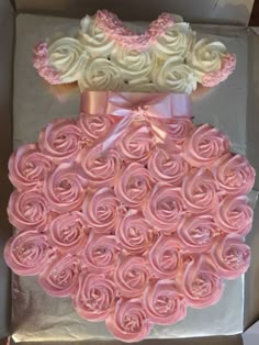 a box filled with pink cupcakes in the shape of a princess's dress