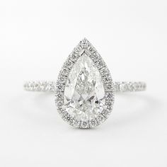 a pear shaped diamond ring with pave set shoulders