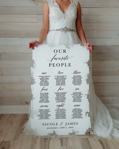 a woman in a wedding dress holding up a seating chart for a ceremony or reception