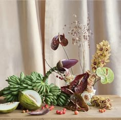 a wooden table topped with lots of different types of fruits and vegetables on top of it