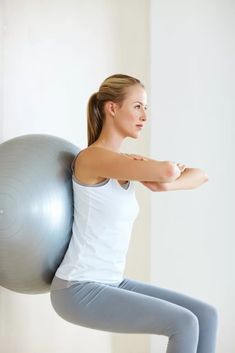 a woman is doing exercises on an exercise ball while holding her arms behind her back