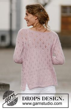 a woman wearing a pink sweater and white pants