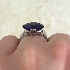 This antique ring features a cushion cut amethyst weighing 4.58 carats. The amethyst is prong-set in platinum. Hand engravings and fine milgrain adorn the shank. This ring bears French import marks and was handcrafted in platinum during the Art Deco era, circa 1920.
The measurements of this ring including the platinum prongs are 13.41mm x 13.28mm.
This ring is currently sized at 6.75 and can be resized at no extra cost.
Ready to Make It Yours? Contact us to reserve this ring and to get more info 1920 Art, 1920 Art Deco, Ring Bear, Arusha, Antique Ring, Art Deco Era, Hand Engraving, Antique Rings, Cushion Cut