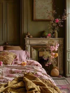 a bed with pink and yellow comforter next to a fire place in a bedroom